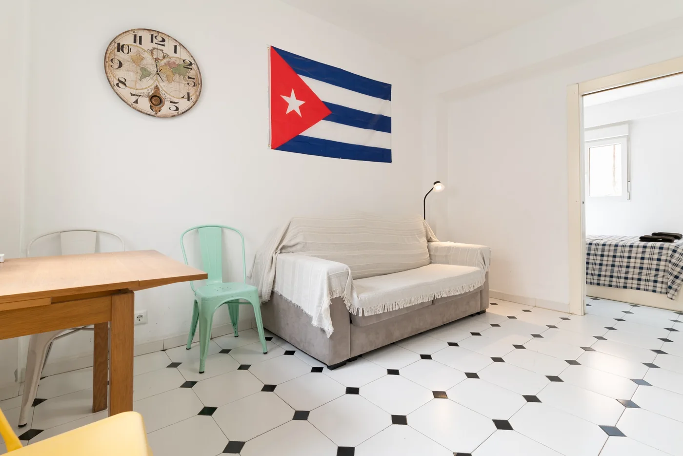 Salón de El Rinconcito Cubano en el Centro con sofá, mesa y bandera cubana